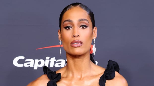 Skylar Diggins-Smith poses for the camera in a ruffled black dress.